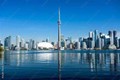 View of the City of Toronto skyline, featuring prominent buildings such as the CN Tower and modern skyscrapers against a clear blue sky